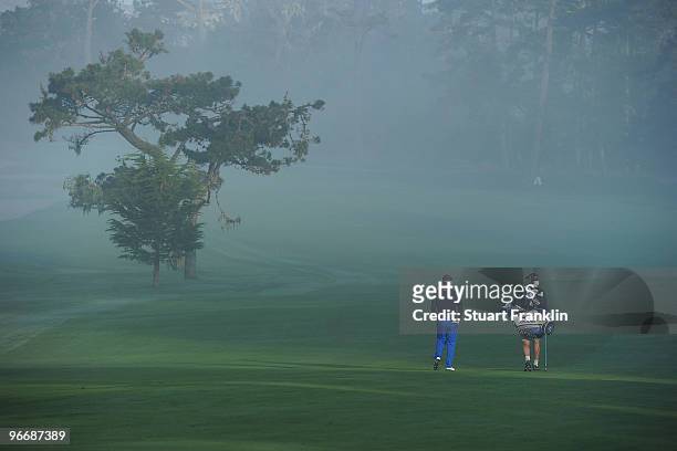 Luke Donald of England and his caddy walk the fairway on the first hole during round three of the AT&T Pebble Beach National Pro-Am at Spyglass Hill...