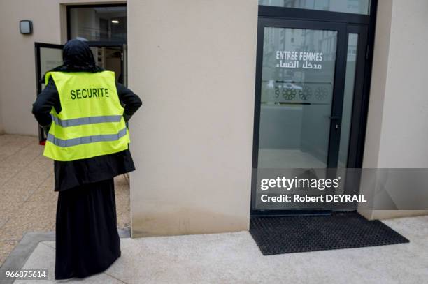 Femme voilée avec un gilet fluorescent assurant la sécurité lors de l'inauguration de la nouvelle mosquée ?el Tawba? le 18 novembre 2016, Lyon,...