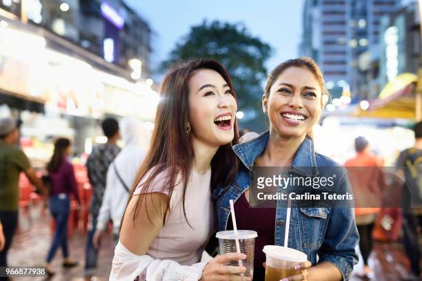 Two Malaysian woman with drinks at a night market