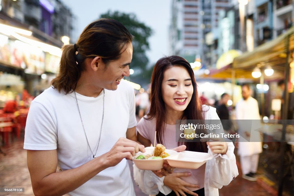 Couple eating dumplings at a night market
