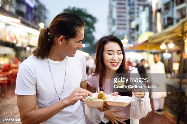 couple eating dumplings at a night market - behållare för farligt avfall bildbanksfoton och bilder
