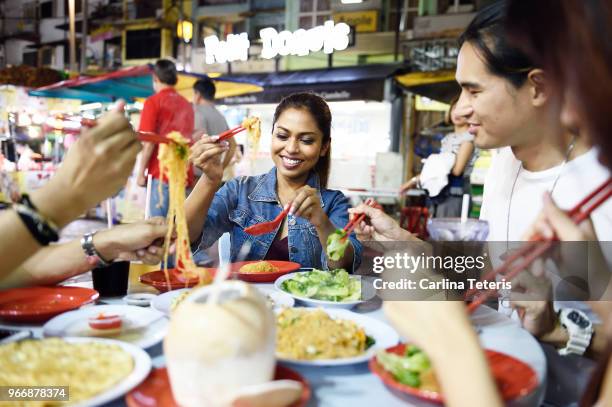 Group of friends eating dinner at a night market table