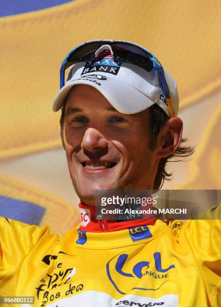 Overall leader's yellow jersey Luxembourger Frank Schleck jubilates on the podium, on July 22 at the end of the 157 km sixteenth stage of the 2008...