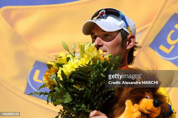 Overall leader's yellow jersey Luxembourger Frank Schleck jubilates on the podium, on July 22 at the end of the 157 km sixteenth stage of the 2008...
