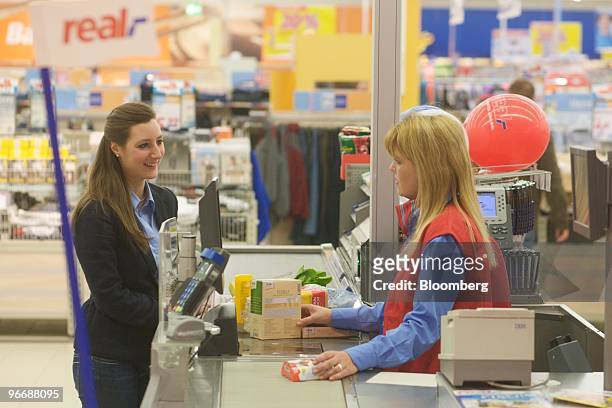 Employee Nicole Lohn, right, rings up customer Serra Esatoglu's purchases inside a Real store, owned by Metro AG, in Toenisvorst, Germany, on Friday,...