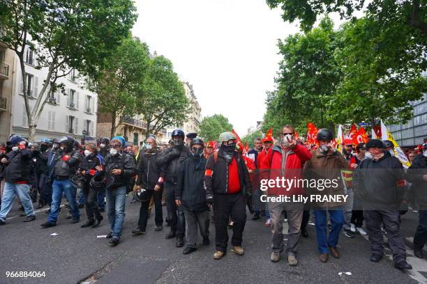 Service d'ordre syndical casqué et masqué se protégeant des gaz lacrymogène et des projectiles des casseurs sur le parcours de la manifestation...