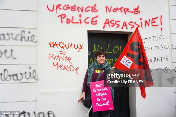 Manifestante devant les murs tagués avec des inscriptions 'Urgence notre police assassine', et affiche 'Tout le monde déteste la loi travail' sur le...