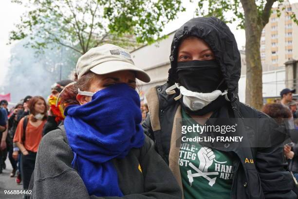 Deux jeunes femmes avec le visage caché lors de la manifestation contre la loi travail dite 'Loi El Khomri', le 26 mai 2016, Paris, France.