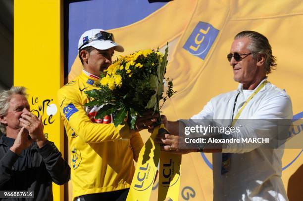 Spanish co-team leader Carlos Sastre jubilates on the podium with his new yellow jersey, on July 23 at the end of the 210,5 km seventeenth stage of...