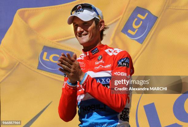 Overall leader's yellow jersey Luxembourger Frank Schleck jubilates on the podium, on July 22 at the end of the 157 km sixteenth stage of the 2008...