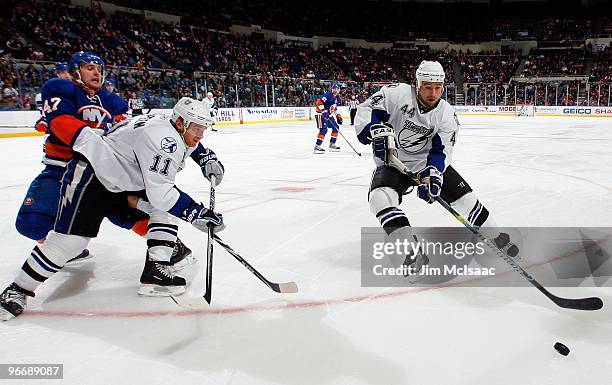 Nate Thompson and Jeff Halpern of the Tampa Bay Lightning skate against Andrew MacDonald of the New York Islanders on February 13, 2010 at Nassau...