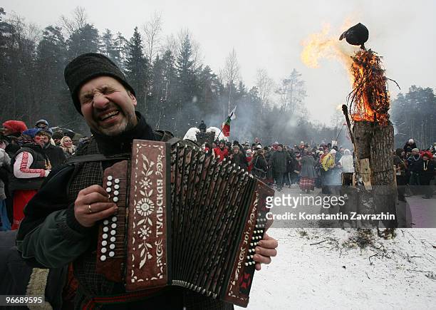 Man plays accordion as an effigy of Lady Maslenitsa burns during celebrations for Maslenitsa , also known as Winter farewell holiday, on February 14,...