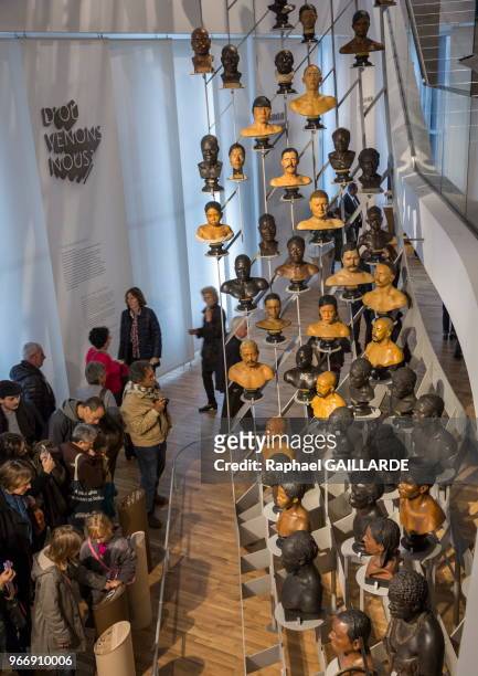 Public admirant le grand portant en forme de portée de musique, 79 bustes de plâtre et 12 de bronze illustrent la diversité humaine, exposée au Musée...