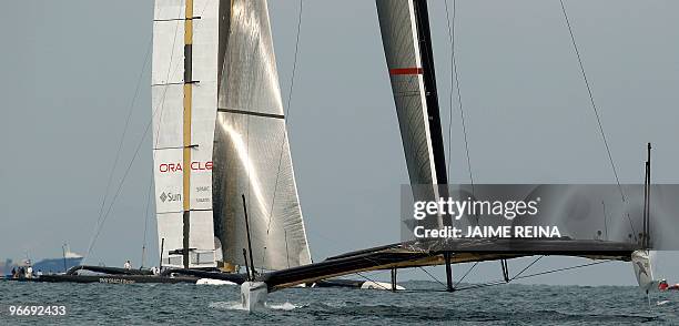 Challenger Oracle giant trimaran and Swiss defender Alinghi huge catamaran sail during the second race of the 33rd America's Cup on February 14, 2010...