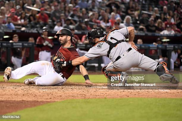 Realmuto of the Miami Marlins tags out Daniel Descalso of the Arizona Diamondbacks at home plate in the seventh inning of the MLB game at Chase Field...