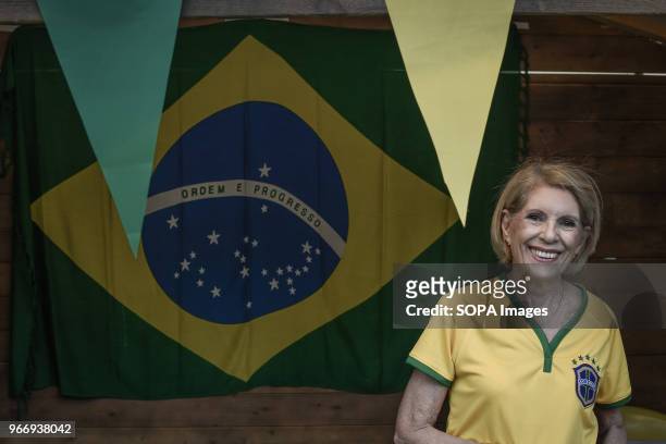 Brazilian female seen in front of a big Brazilian flag during a festival in Athens about traditional Latin-American culture with food, drinks, Latin...