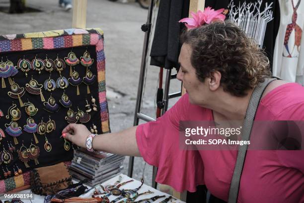 Female seen looking at the products for sale at the festival in Athens about traditional Latin-American culture with food, drinks, Latin dances,...