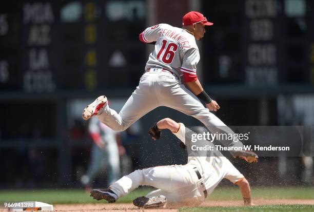 Cesar Hernandez of the Philadelphia Phillies completes the double-play throwing over the top of Joe Panik of the San Francisco Giants in the bottom...