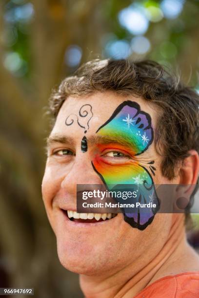 a father having his face painted - face paint stock-fotos und bilder