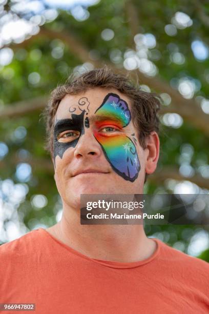 a father having his face painted - face paint stock-fotos und bilder
