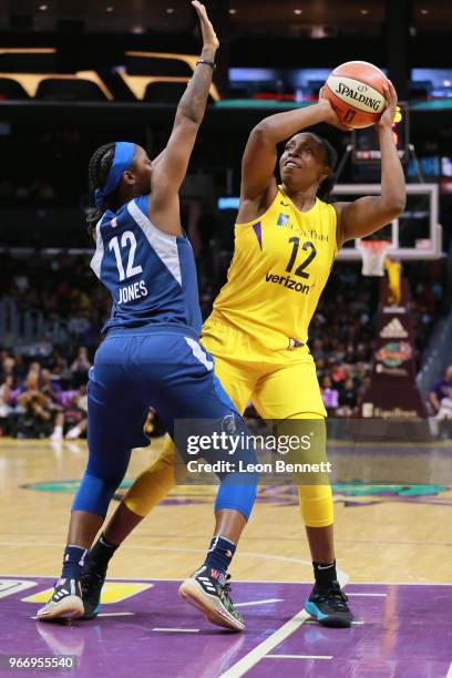 Chelsea Gray of the Los Angeles Sparks handles the ball against Alexis Jones of the Minnesota Lynx during a WNBA basketball game at Staples Center on...