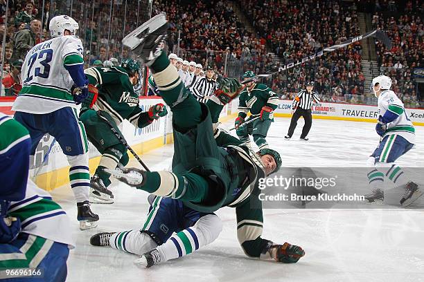 Derek Boogaard of the Minnesota Wild is dragged down to the ice by Darcy Hordichuk of the Vancouver Canucks during the game at the Xcel Energy Center...