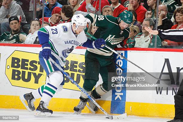 Alexander Edler of the Vancouver Canucks and Guillaume Latendresse of the Minnesota Wild battle for the puck along the boards during the game at the...