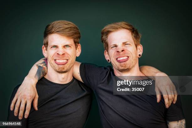 zwillingsbrüder machen dumme gesicht grimasse - cloning stock-fotos und bilder