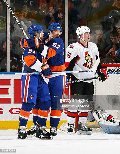 Blake Comeau of the New York Islanders is congratulated on his second goal of the game at 13:57 in the second period by teammate Doug Weight while...