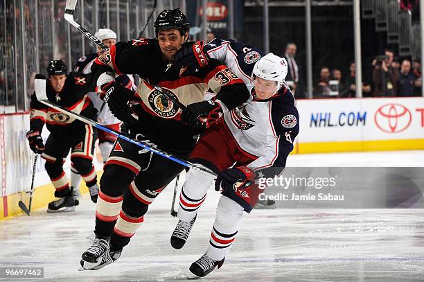 Anton Stralman of the Columbus Blue Jackets battles for positioning with Dustin Byfuglien of the Chicago Blackhawks during the second period on...