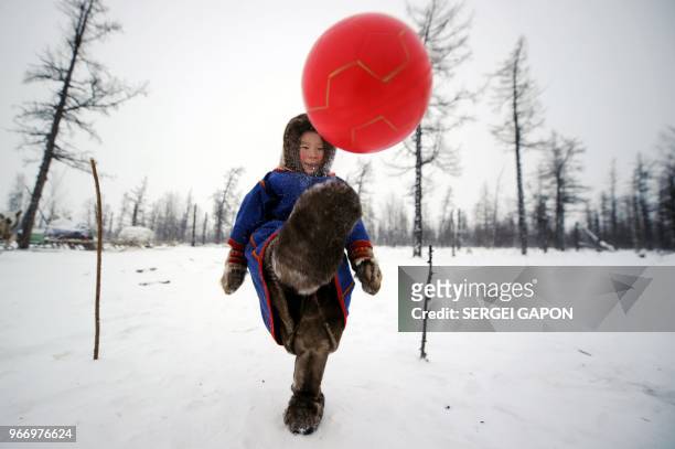 Children of reindeer herders play with a ball on the snow in the remote Yamalo-Nenets region of northern Russia on March 6, 2018.