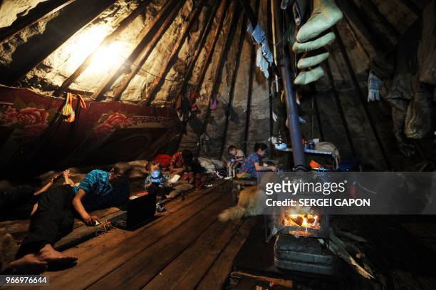 Reindeer herders and their children rest inside a tent in the remote Yamalo-Nenets region of northern Russia on March 6, 2018.