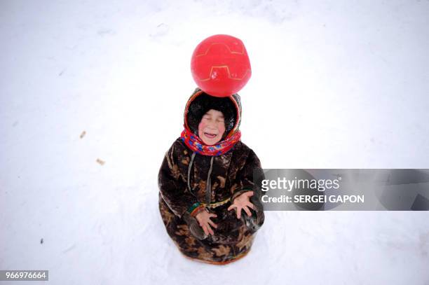 Children of reindeer herders play with a ball on the snow in the remote Yamalo-Nenets region of northern Russia on March 6, 2018.