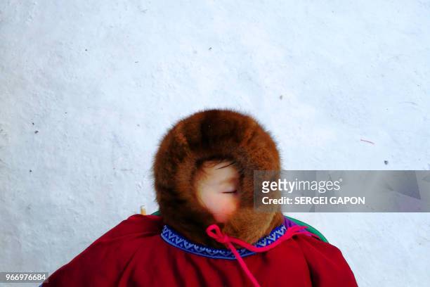 Child sleeps on the snow in the remote Yamalo-Nenets region of northern Russia on March 4, 2018.