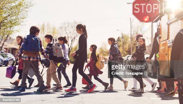 crianças da escola atravessando a rua - travessia de pedestres marca de rua - fotografias e filmes do acervo