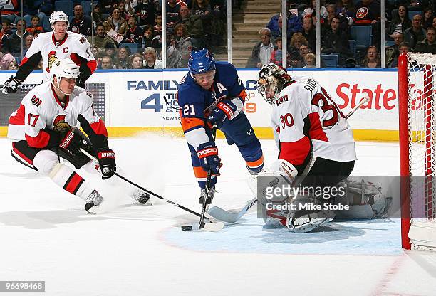 Goaltender Brian Elliott of the Ottawa Senators and teammate Filip Kuba defend the net against Kyle Okposo of the New York Islanders on February 14,...