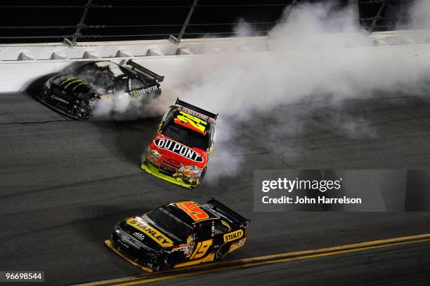 Elliott Sadler, driver of the Stanley Ford, drives by as Jeff Gordon, driver of the DuPont Chevrolet, and Robby Gordon, driver of the Monster Energy...