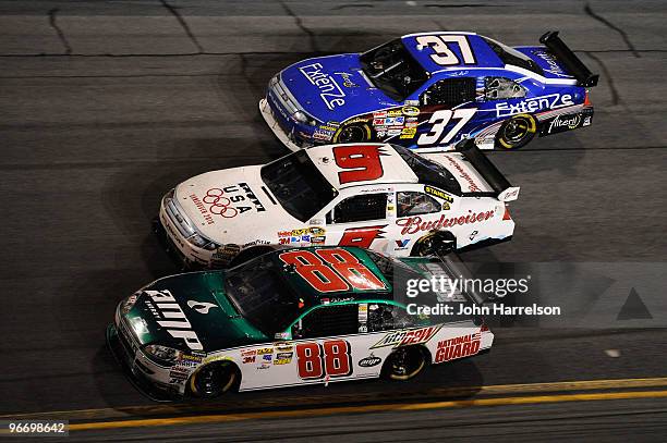 Dale Earnhardt Jr., driver of the AMP Energy/National Guard Chevrolet, races Kasey Kahne, driver of the Budweiser Ford, and Travis Kvapil, driver of...