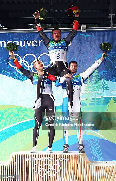 Gold medallist Felix Loch of Germany is held aloft by silver medallist David Moeller of Germany and bronze medallist Armin Zoeggeler of Italy after...