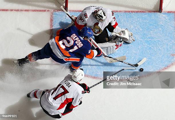 Brian Elliott and Filip Kuba of the Ottawa Senators combine to stop a scoring chance from Kyle Okposo of the New York Islanders on February 14, 2010...