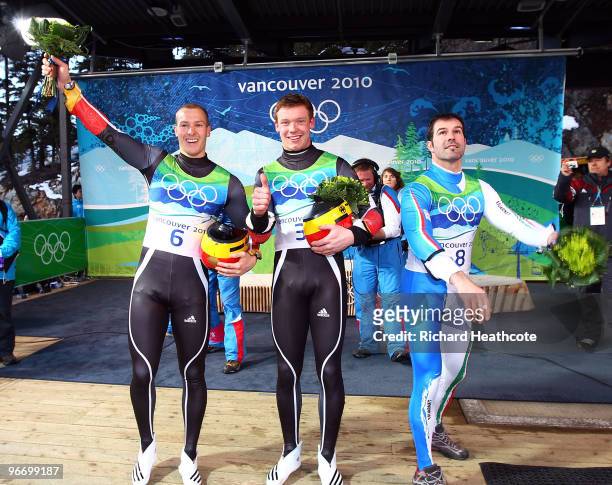 Gold medallist Felix Loch of Germany celebrates with silver medallist David Moeller of Germany and bronze medallist Armin Zoeggeler of Italy after...
