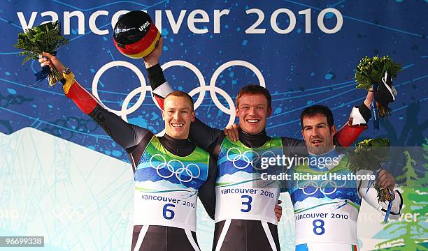 Gold medallist Felix Loch of Germany celebrates with silver medallist David Moeller of Germany and bronze medallist Armin Zoeggeler of Italy after...