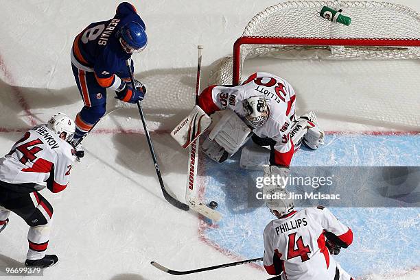 Brian Elliott, Chris Phillips and Anton Volchenkov of the Ottawa Senators combine to stop a scoring chance from Bruno Gervais of the New York...