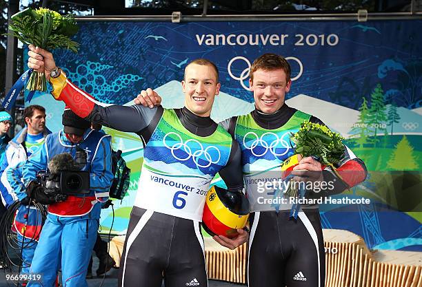 Felix Loch and David Moeller of Germany celebrate winning the gold and silver medials respectively after the final run of the men's luge singles...