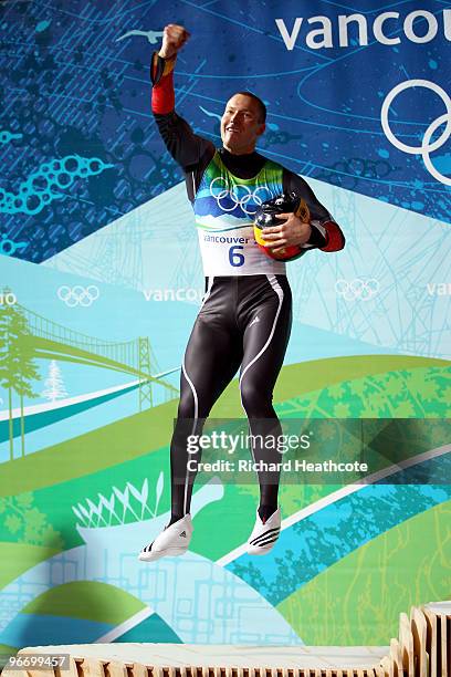 David Moeller of Germany celebrates on the podium after winning the silver medal after the final run of the men's luge singles final on day 3 of the...