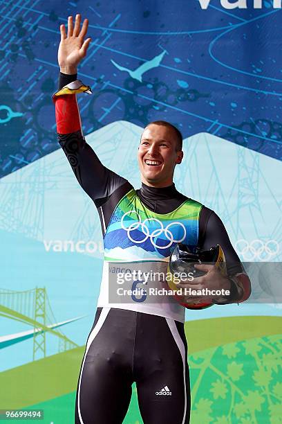 David Moeller of Germany celebrates on the podium after winning the silver medal after the final run of the men's luge singles final on day 3 of the...