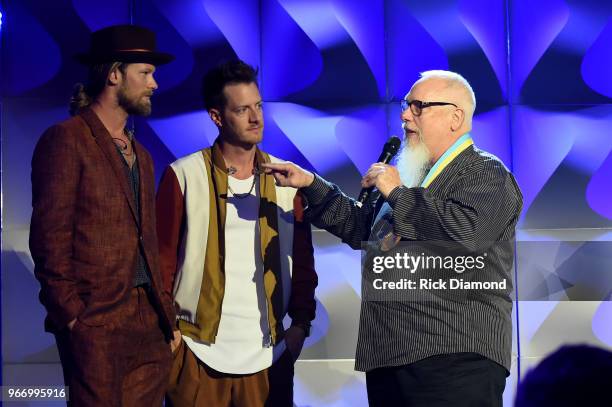 Brian Kelly and Tyler Hubbard, of Florida Georgia Line, present an award to Spotify's John Marks onstage at the Innovation In Music Awards on June 3,...