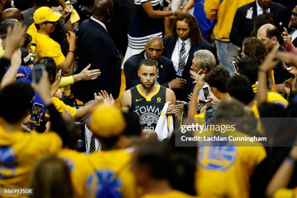 Stephen Curry of the Golden State Warriors high fives fans as he leaves the floor after they defeated the Cleveland Cavaliers in Game 2 of the 2018...