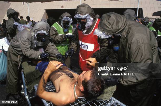 Un homme est secouru lors d'une simulation de guerre chimique durant la crise du Golfe le 27 septembre 1990 à Haïfa, Israël.