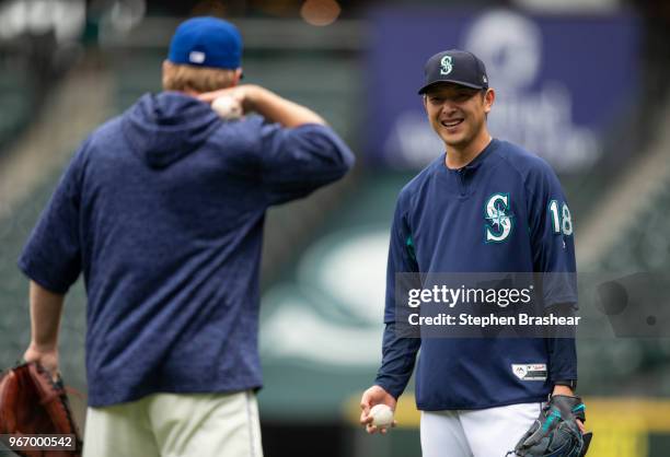 Hisashi Iwakuma of the Seattle Mariners smiles while talking with Seattle Mariners pitching coach Mel Stottlemyre before a game against the Tampa Bay...